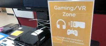Sign reading Gaming/VR zone and a large TV monitor