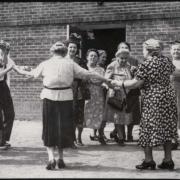 A group of Jewish women gather in a circle, holding hands and dancing