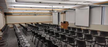 Andersen Library room 120 set up with lecture style seating, chairs in rows and lecturn at the front