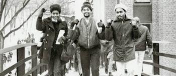 Three students of the Afro-American Action Committee walking across bridge with fists in the air
