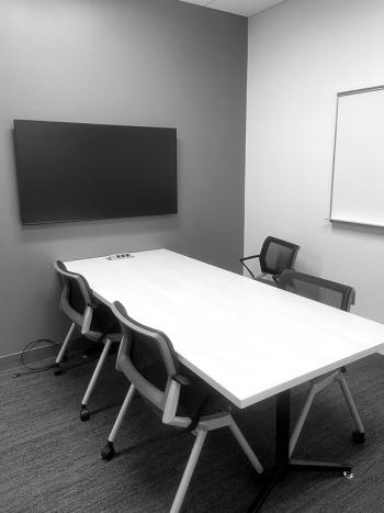 Room with table, chairs, whiteboard, and monitor