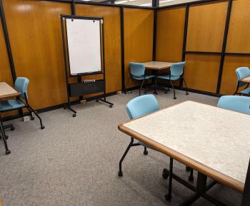 Enclosed room with four tables, each with two chairs.