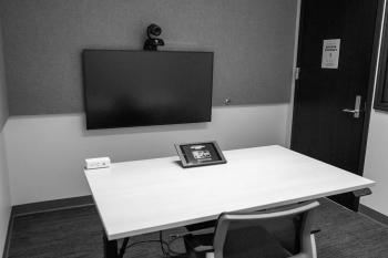 Room with monitor, desk with tablet, and chair