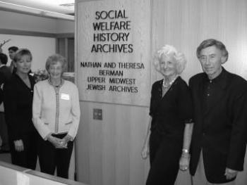 Four members of the Berman family stand by the sign for the Berman Upper Midwest Jewish Archives