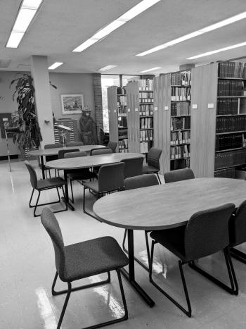Tables and chairs near library shelving