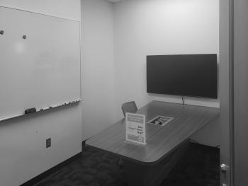 Room with table, chairs, monitor and whiteboard