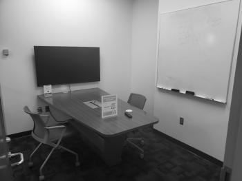 Tables with chairs, monitor, and whiteboard